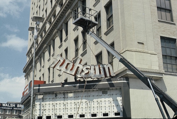 A crane removes the broken Orpheum lights sign from the marquee. The Orpheum was a movie theater before it became a performing arts center.